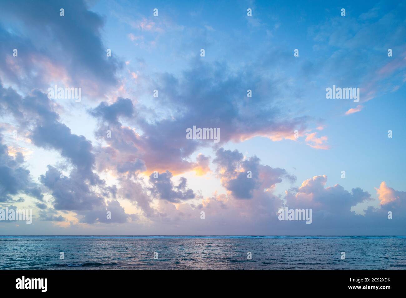 Beautiful pink and orange clouds at sunrise over the Caribbean Sea, Grand Cayman Island Stock Photo