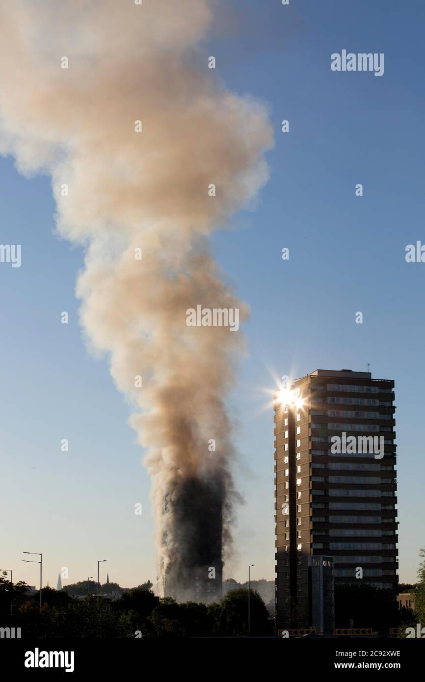 Smoke rises from the fire at the Grenfell Tower, a 24-storey apartment block part of the Lancaster West Estate in North Kensington, London, UK. The fire was started early morning by a malfunctioning fridge-freezer on the fourth floor. It spread rapidly up the building's exterior, via the external cladding and insulation. The fire caused 72 deaths, including those of two victims who later died in hospital. More than 70 others were injured and 223 people escaped. It was the deadliest structural fire in the United Kingdom since the 1988 and the worst UK residential fire since the Second World War Stock Photo