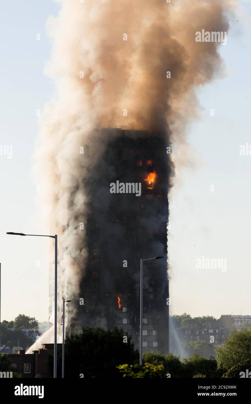 Smoke rises from the fire at the Grenfell Tower, a 24-storey apartment block part of the Lancaster West Estate in North Kensington, London, UK. The fire was started early morning by a malfunctioning fridge-freezer on the fourth floor. It spread rapidly up the building's exterior, via the external cladding and insulation. The fire caused 72 deaths, including those of two victims who later died in hospital. More than 70 others were injured and 223 people escaped. It was the deadliest structural fire in the United Kingdom since the 1988 and the worst UK residential fire since the Second World War Stock Photo