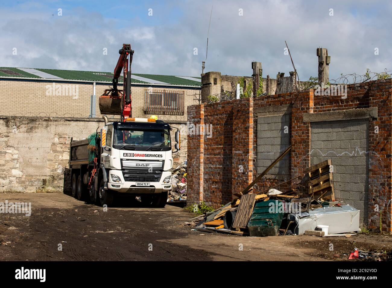 ABD Grab Services clearing a disused site behind a car wash on Crumlin Road in Belfast that has been used as an illegal dump. Woodvale residents complained to local representatives that this site and a second in Edenderry Industrial Estate raised health concerns. Stock Photo