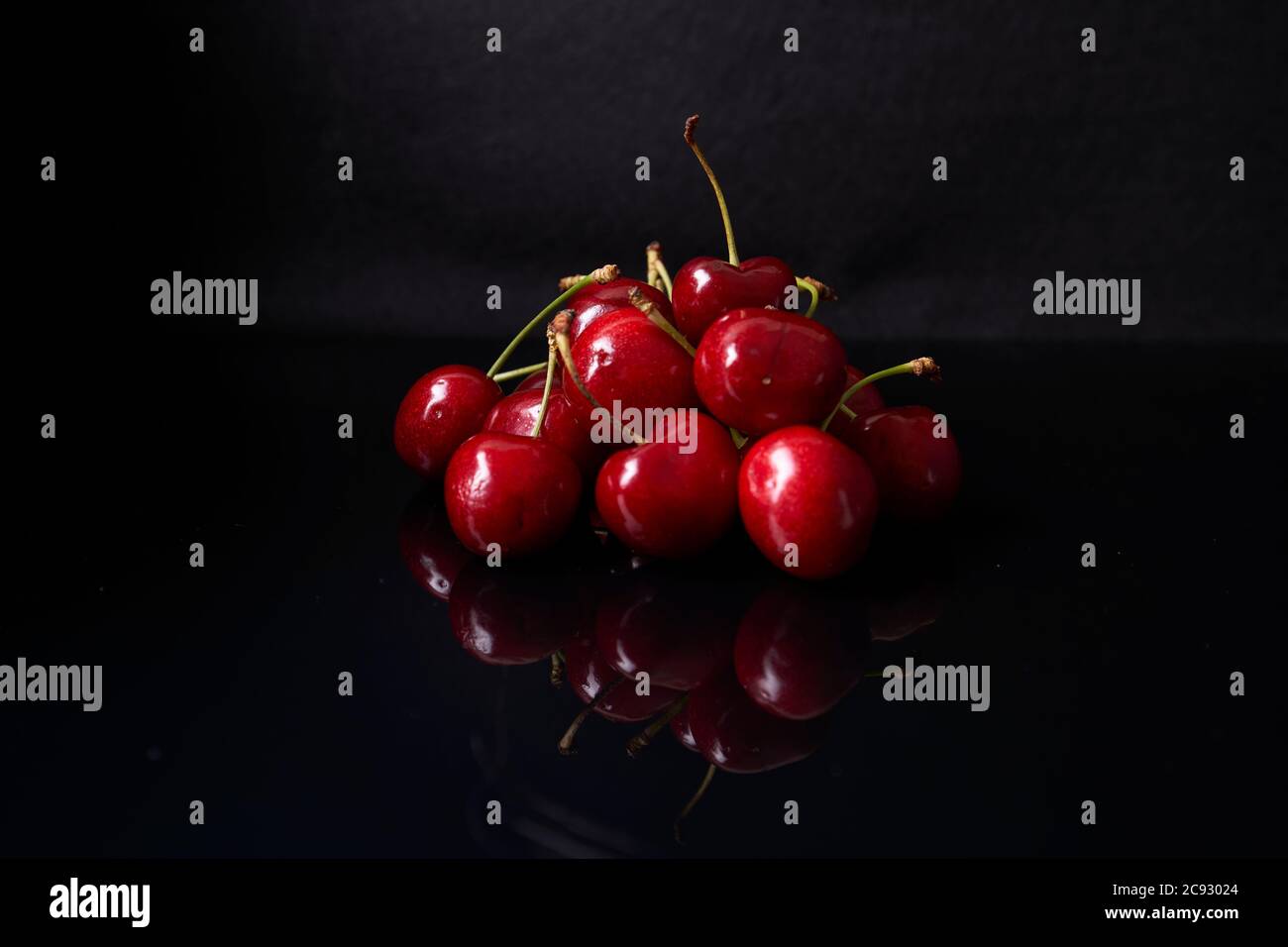 reflection of still life cherries on black background Stock Photo