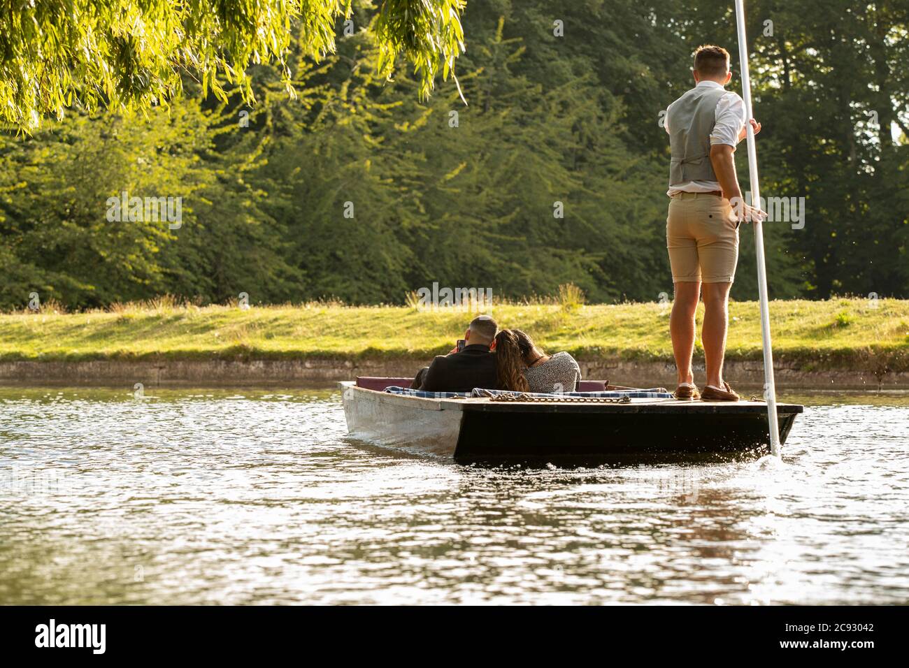 A couple enjoy a chauffeured punt along the river Cam in Cambridge. Stock Photo