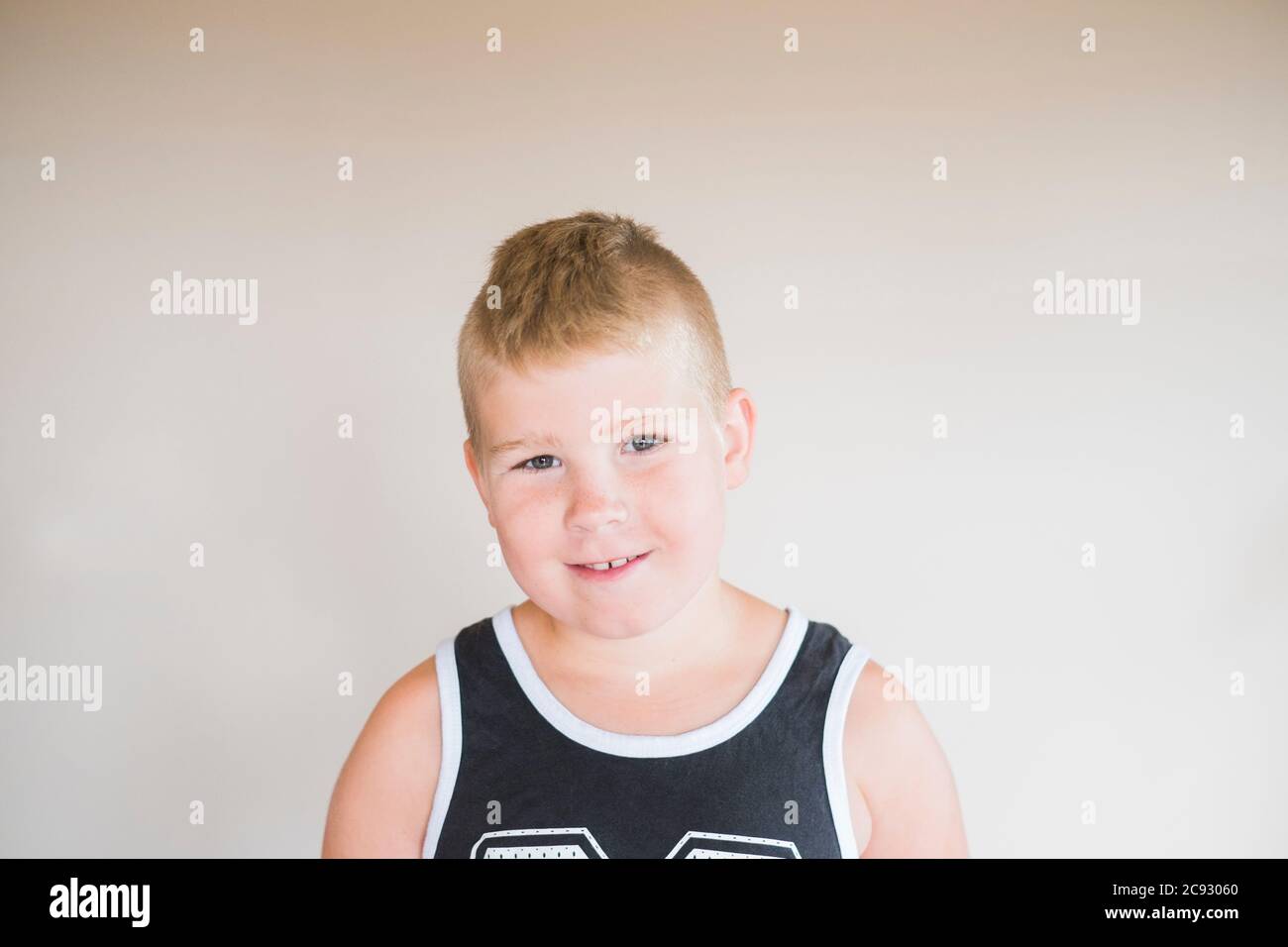 Portrait of a young boy sitting and looking at the camera Stock Photo ...