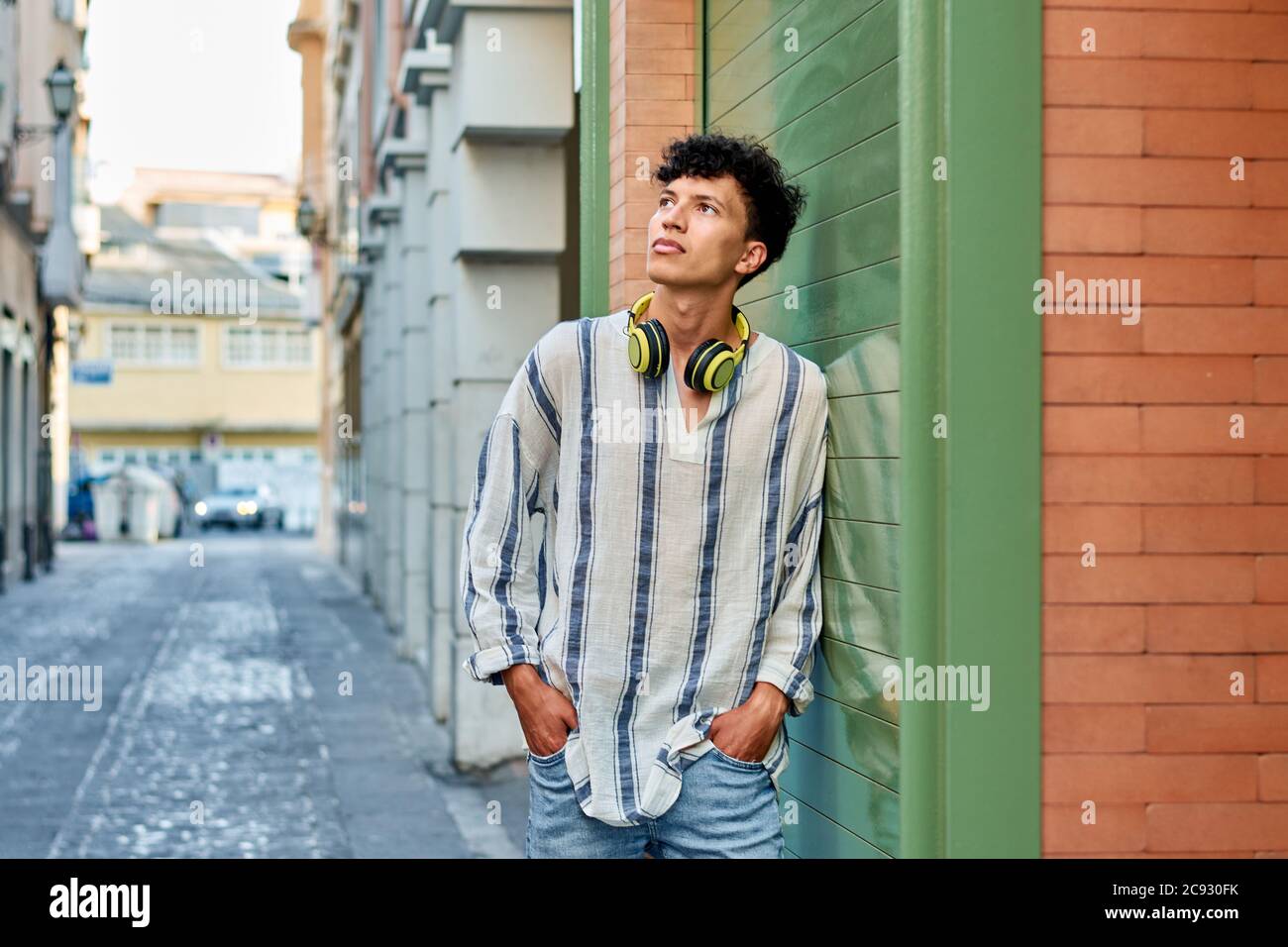 Young afro-haired man with headphones looks up Stock Photo