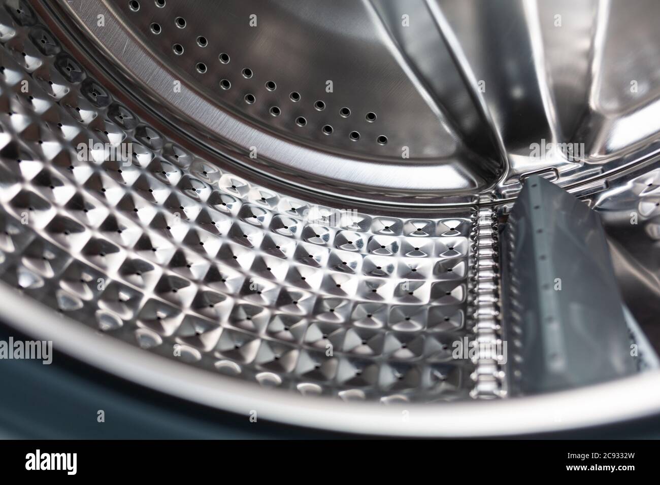 Clean shiny washing machine part of drum closeup. The concept of cleaning appliances from scale
