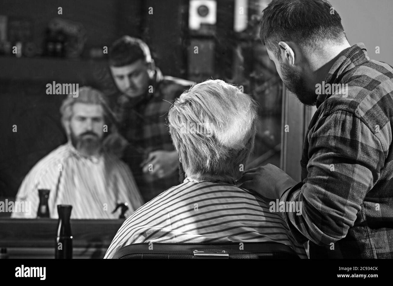 Great time at barbershop. Happy guy getting haircut by hairdresser. Stock Photo