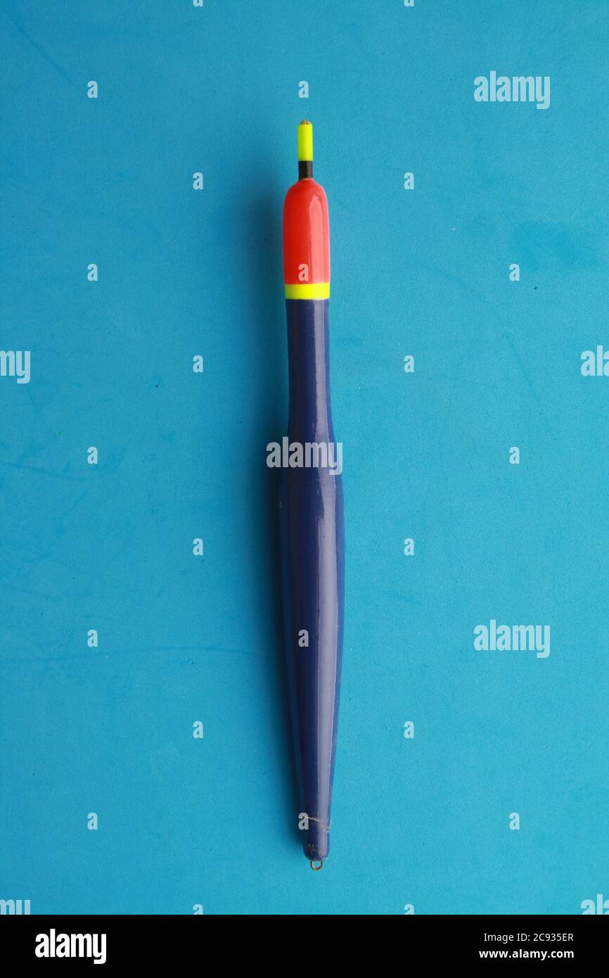 Vertical top view closeup shot of fishing float on a blue background ...
