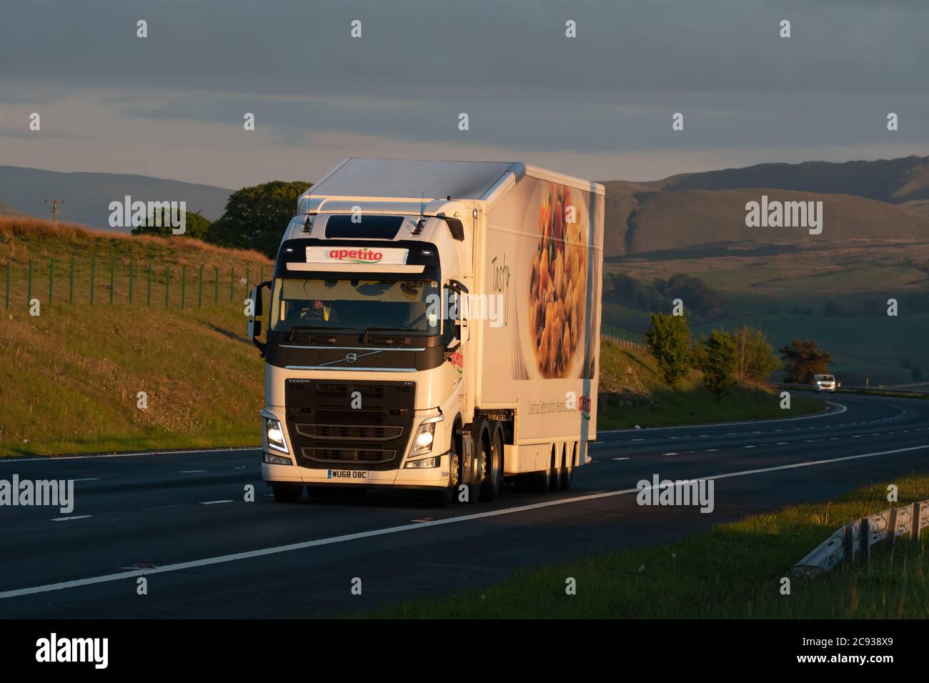 Volvo delivery truck (Apetitio Foods) with dragfoiler and aerodynamic trailer driving along the M74 in Scotland Stock Photo