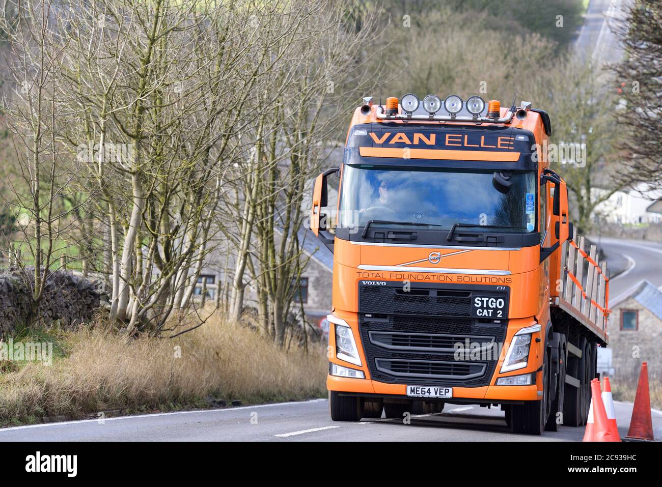 Van Elle Volvo STGO Cat 2 truck with flatbed trailer driving along an A
