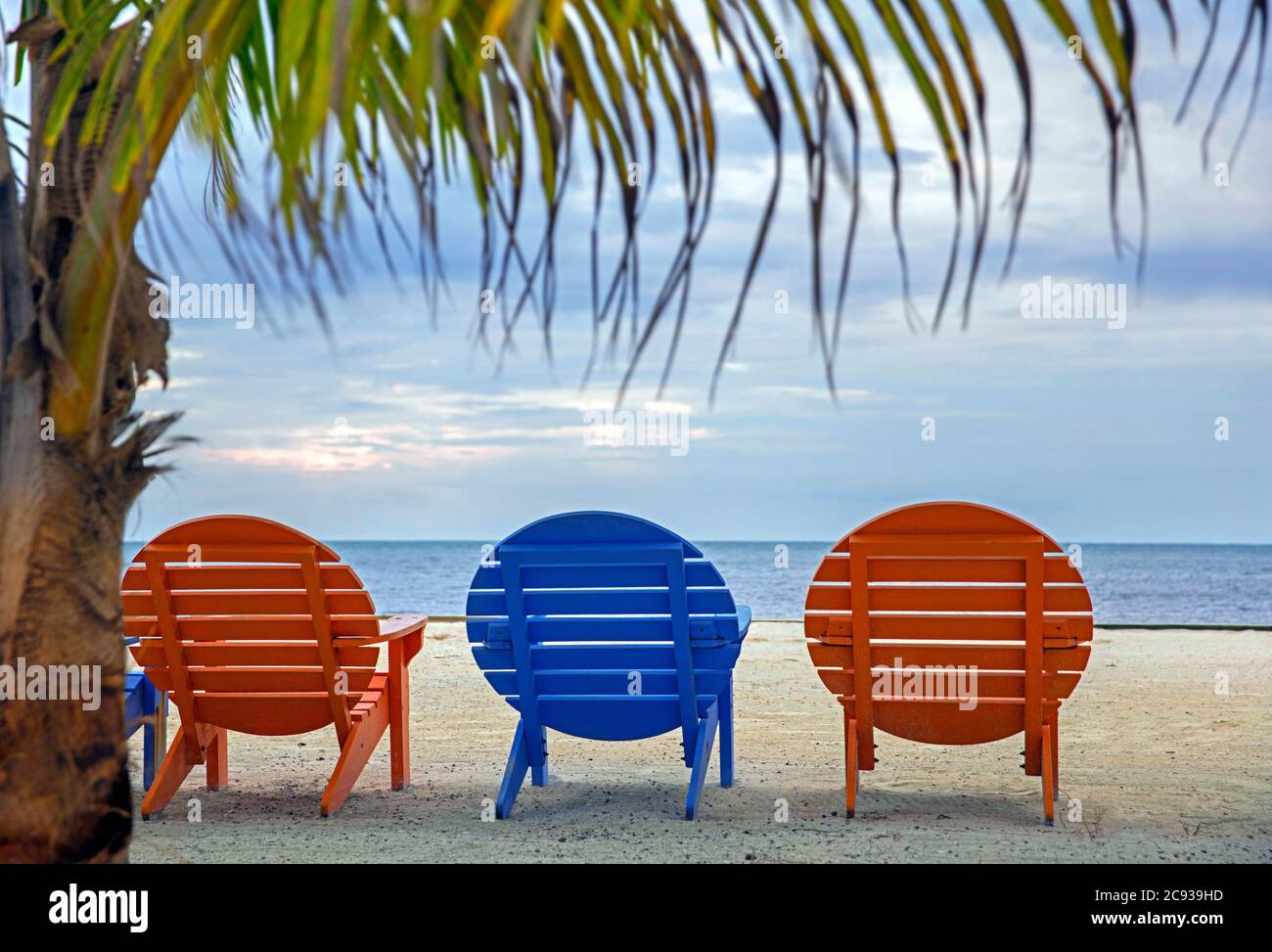 Colorful round wooden beach chairs at holiday resort on Caye Caulker / Cayo Caulker, coral island off the coast of Belize in the Caribbean Sea Stock Photo