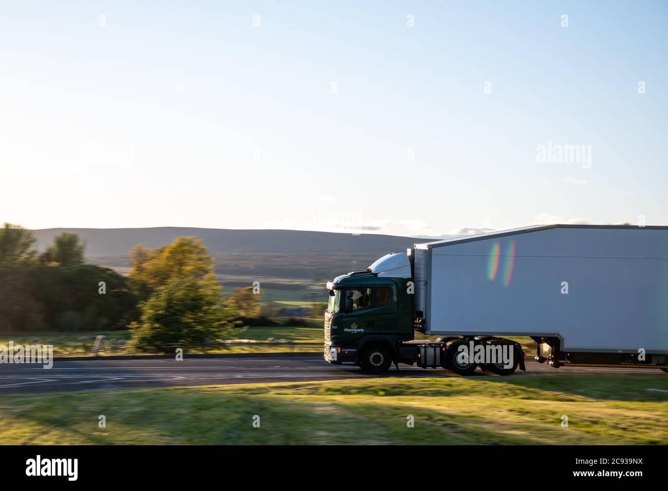 Morrison's supermarket Scania delivery truck with dragfoiler and aerodynamic trailer driving along an A Road in Scotland Stock Photo
