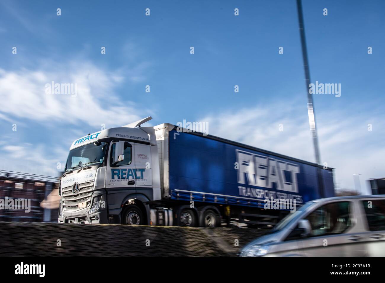 React Transport Mercedes-Benz Actros curtainsider truck driving on an urban dual carriageway Stock Photo