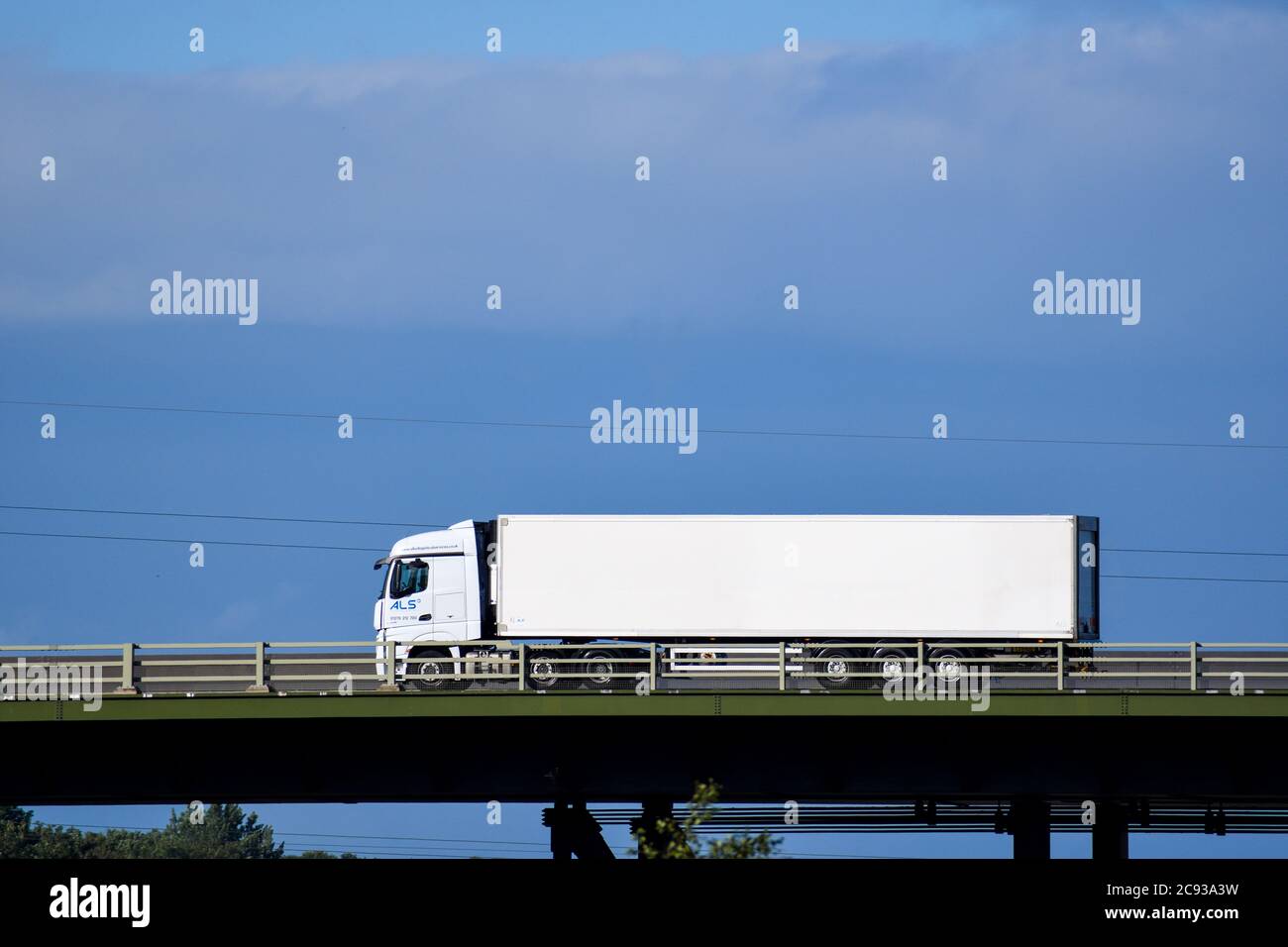 truck pulling a steel box trailer crossing the top deck of Tinsley
