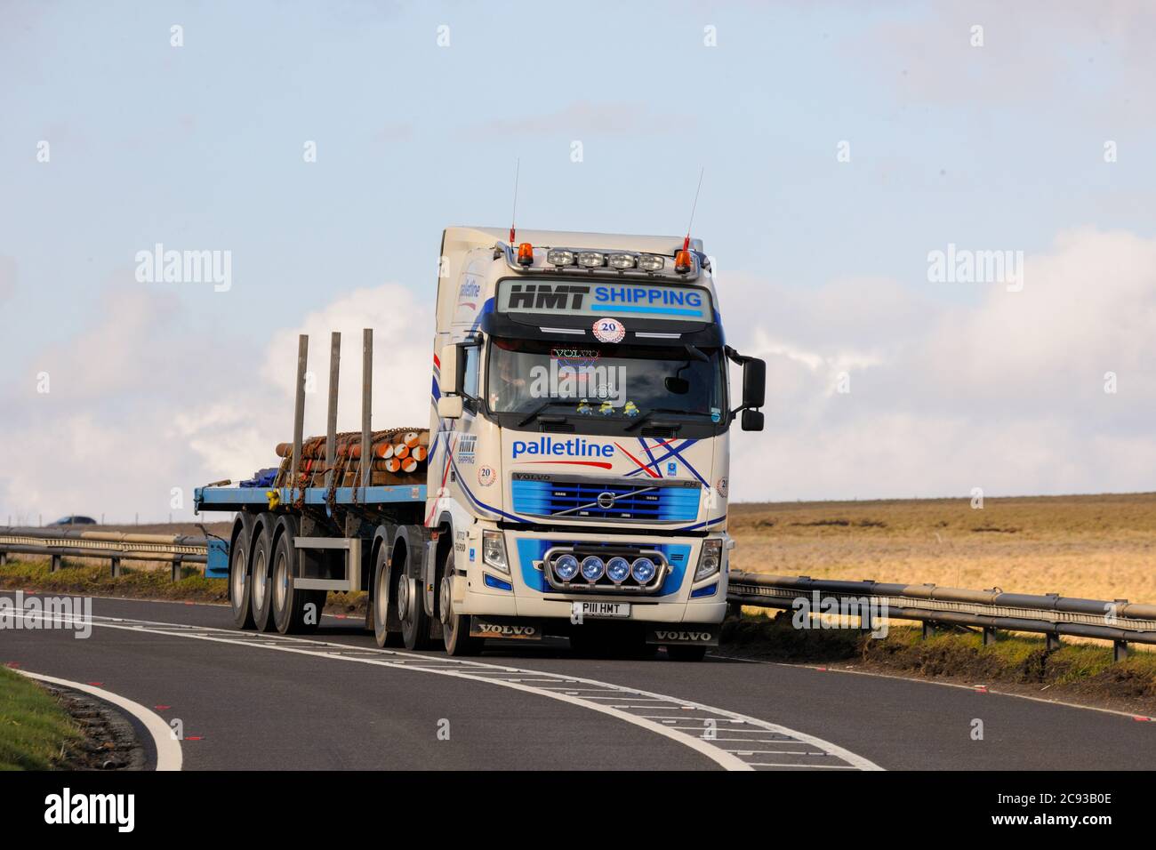 Volvo truck on A628 Woodhead Pass pulling a flatbed trailer carrying steel bars Stock Photo