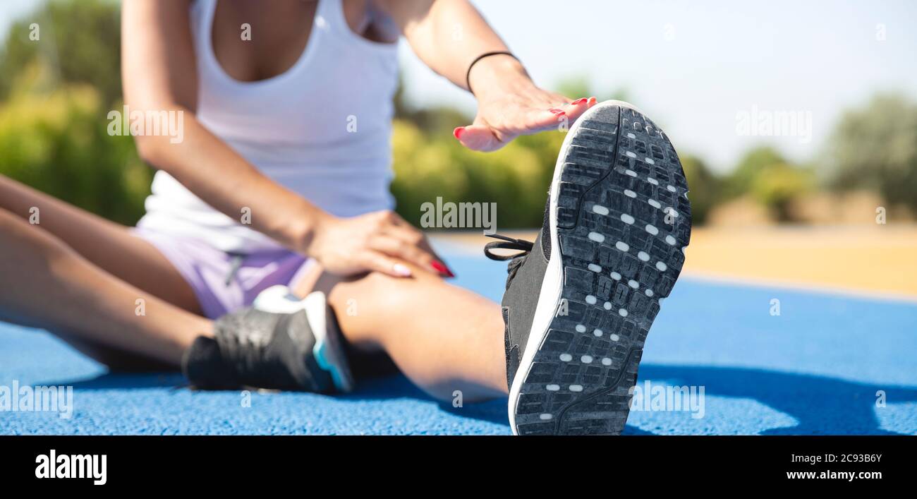 Close-up of a sportswoman stretching outdoors before playing sports. Selective focus. Concept of sport and healthy life. Stock Photo