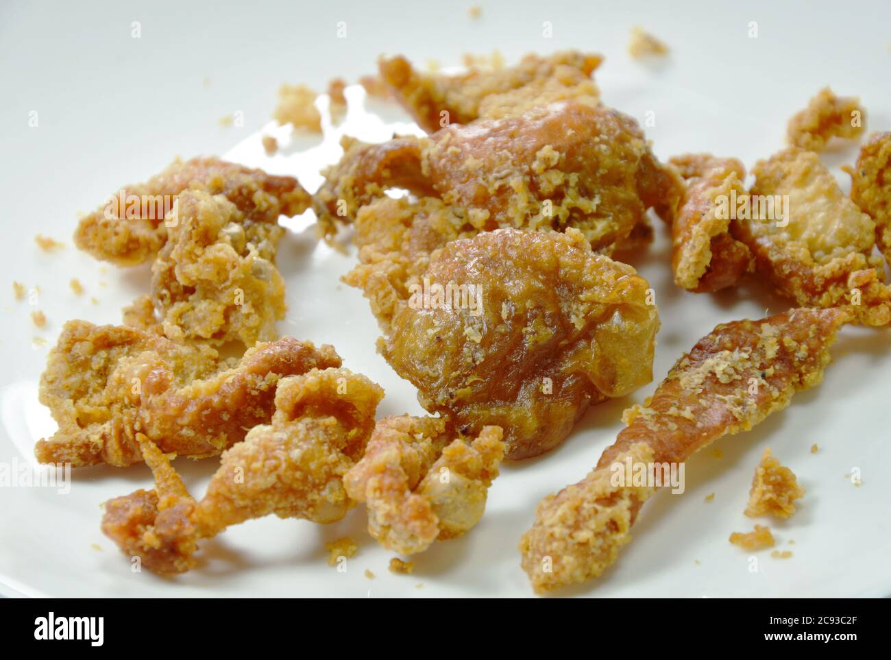 deep fried chicken skin with salt and pepper on white background Stock