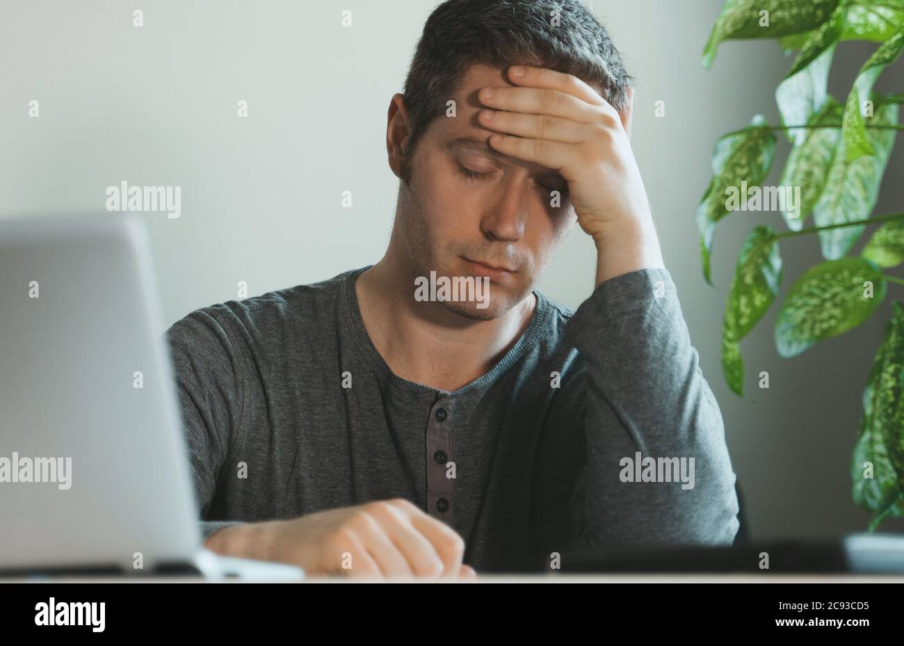 Tired exhausted man with headache in the office Stock Photo Alamy