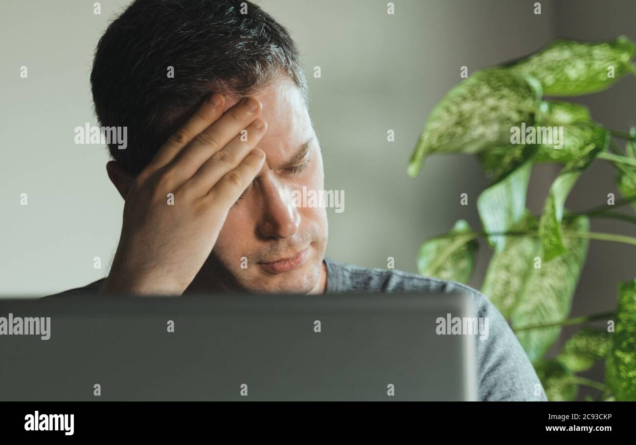 Tired exhausted man with headache in the office Stock Photo Alamy