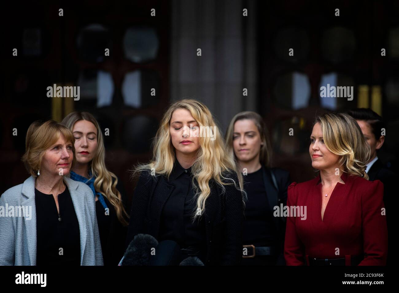 Actress Amber Heard, alongside her sister Whitney Henriquez (second right) and lawyer Jen Robinson (right), as she gives a statement outside the High Court in London on the final day of hearings in Johnny Depp's libel case against the publishers of The Sun and its executive editor, Dan Wootton. After almost three weeks, the biggest English libel trial of the 21st century is drawing to a close, as Mr Depp's lawyers are making closing submissions to Mr Justice Nicol. Stock Photo