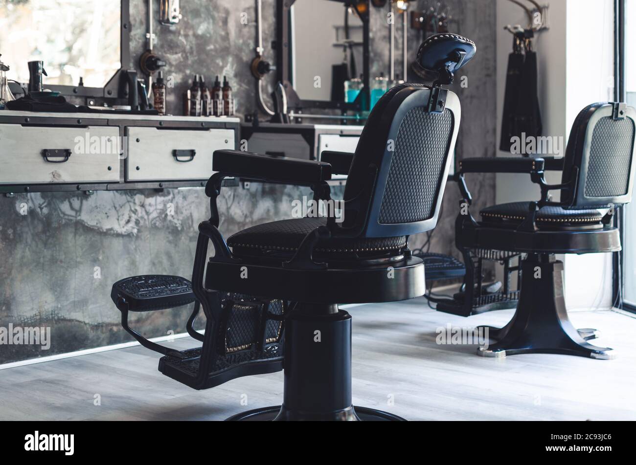 Two black leather and iron barber chairs in an old style barber shop