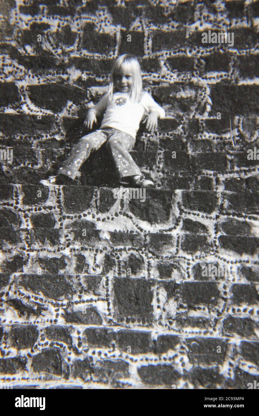 Fine 70s vintage black and white street photography of a cute young tourist taking a break on the Pyramid of the Sun in Teotihuacan, Mexico. Stock Photo