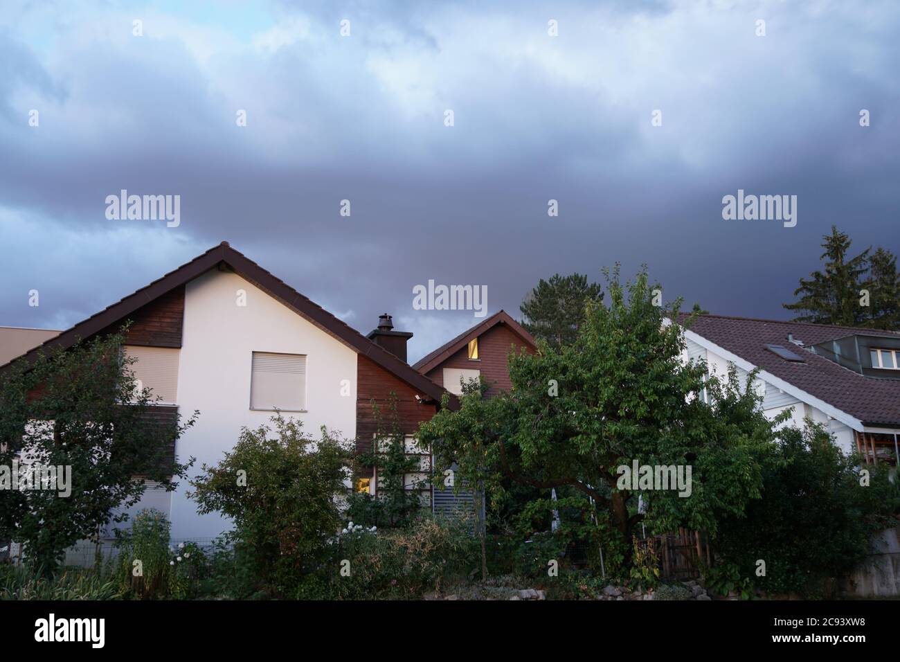 Storm brewing above peaceful residential quarter on a summer evening in Urdorf, Switzerland. Stock Photo