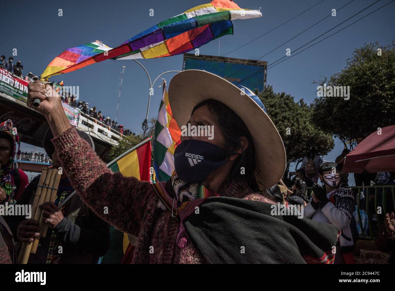 28 July Bolivia El Alto A Woman Wearing An Adidas Face Mask Waves An Indigenous Peoples Flag In A Protest Against The Renewed Postponement Of The Presidential And Parliamentary Elections In