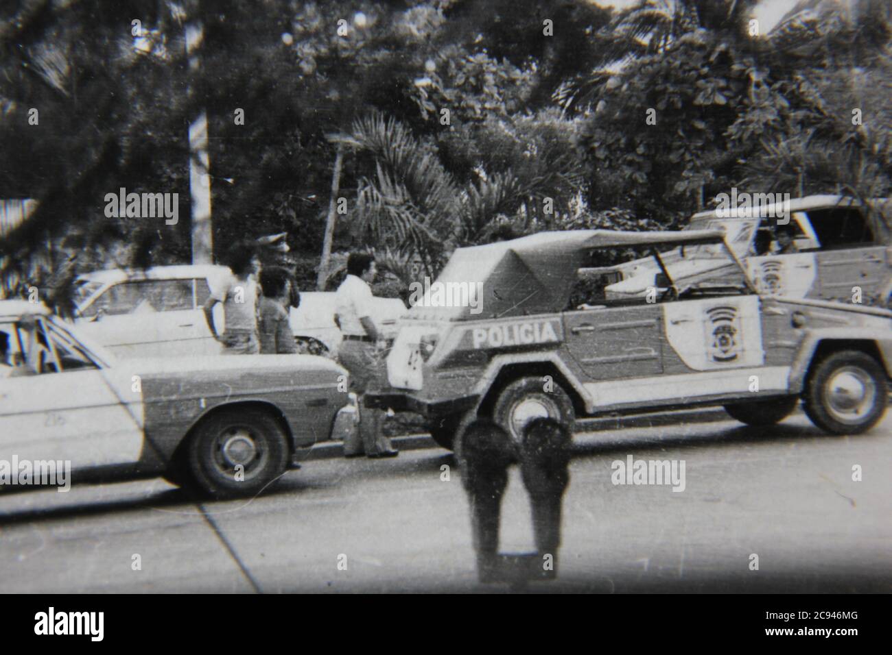 Fine 70s vintage black and white street photography of a policia car and people watching an incident in Mexico. Stock Photo