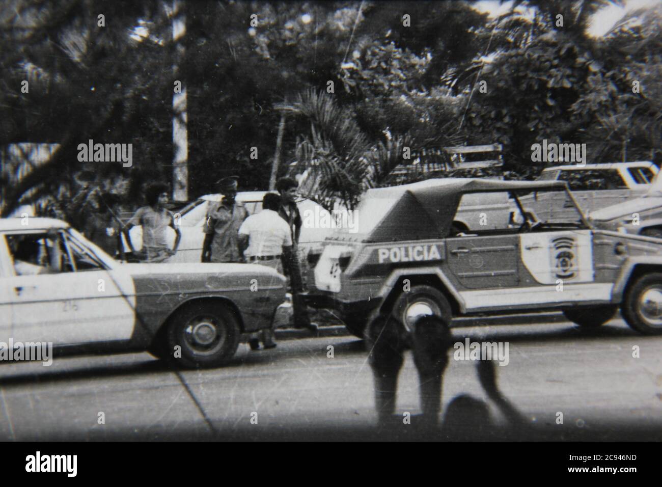 Fine 70s vintage black and white street photography of a policia car and people watching an incident in Mexico. Stock Photo