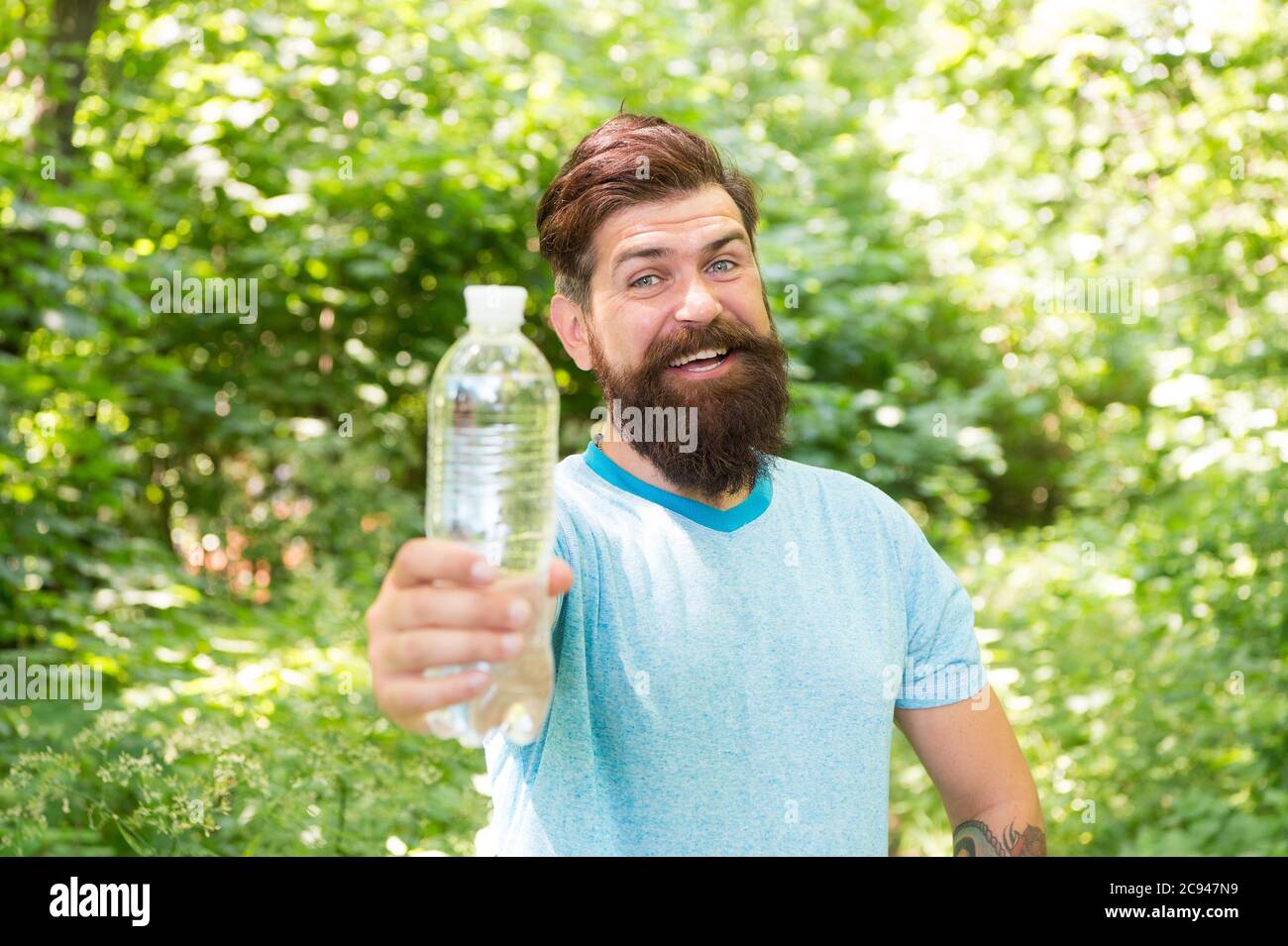 Drink Plenty Of Water. drinking water in forest outdoor with sunset nature on background. Bearded man with water bottle. fitness portrait of bearded man. happy mature guy. thirsty hipster traveler. Stock Photo