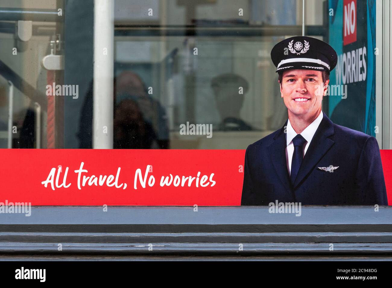 A picture of a pilot with a slogan reading  ‘All Travel, No Worries’  is seen in the Flight Centre store window in Covent Garden, London.All Flight Centre stores remain closed due to the Covid-19 crisis and with the uncertainty of ‘Air Bridges’ such as Spain being pulled, it is a hard tie for Travel Agents. Stock Photo