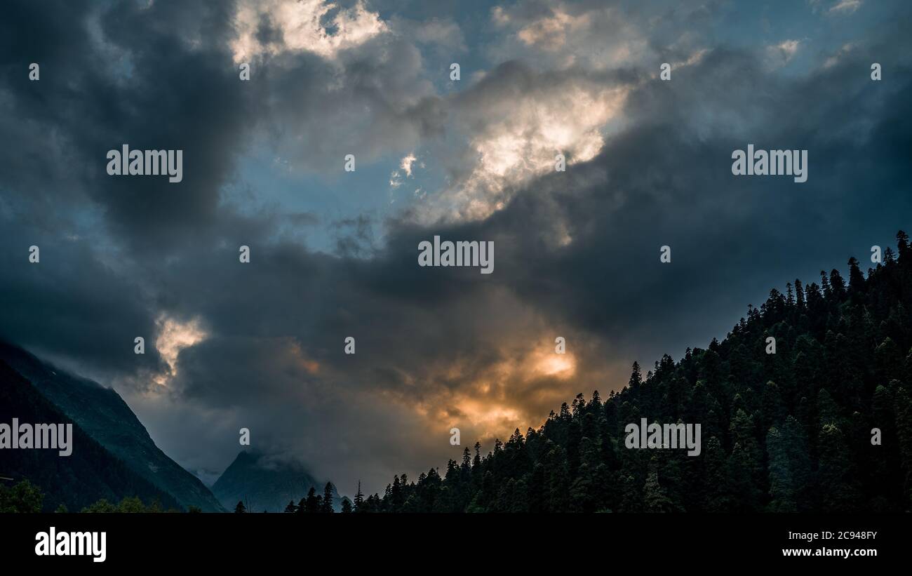 Beautiful landscape of evening sky with clouds in mountainous area. Clouds float tightening sky. Stock Photo