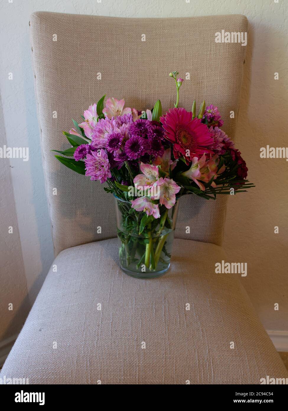 Vase of Flowers on Beige Chair Stock Photo