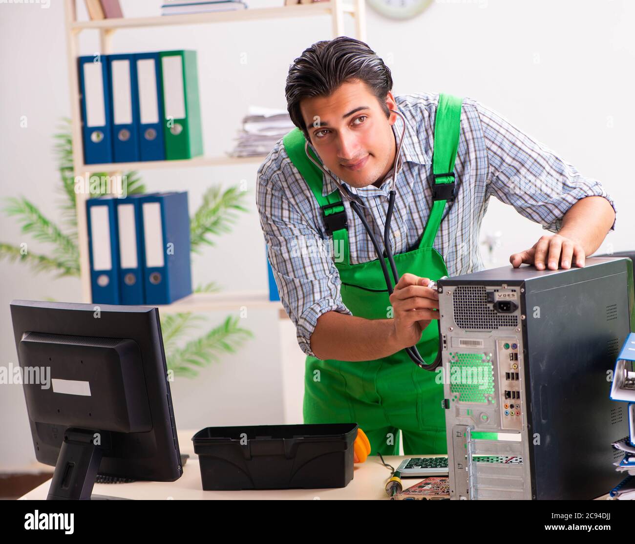 The young engineer repairing broken computer at the office Stock Photo ...