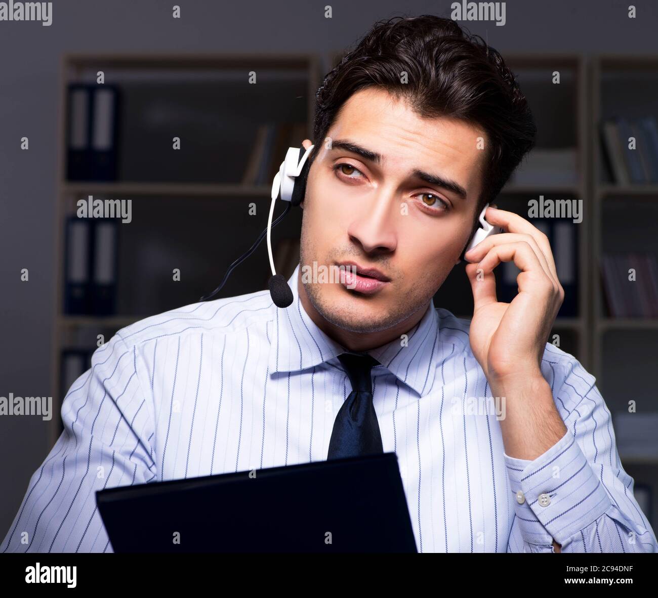 The call center operator talking to customer during night shift Stock