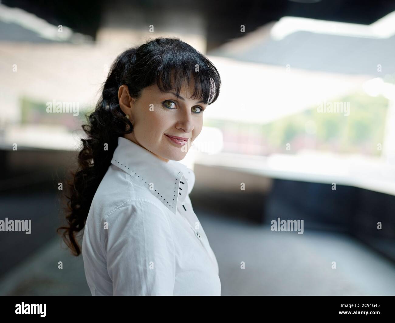 Mature Businesswoman Smiling And Looking At Camera Outdoors Stock Photo
