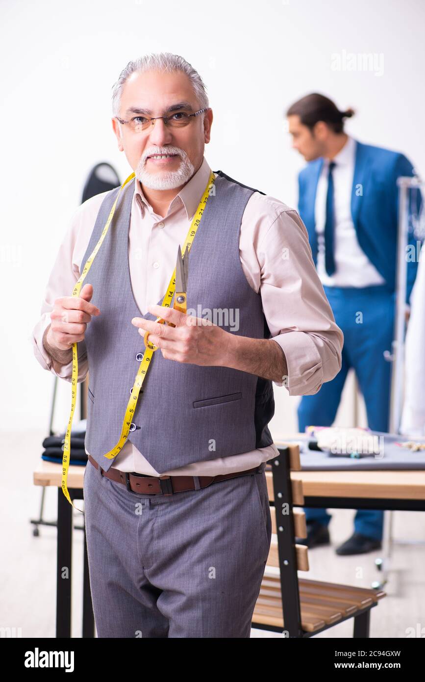 Young businessman visiting old tailor Stock Photo