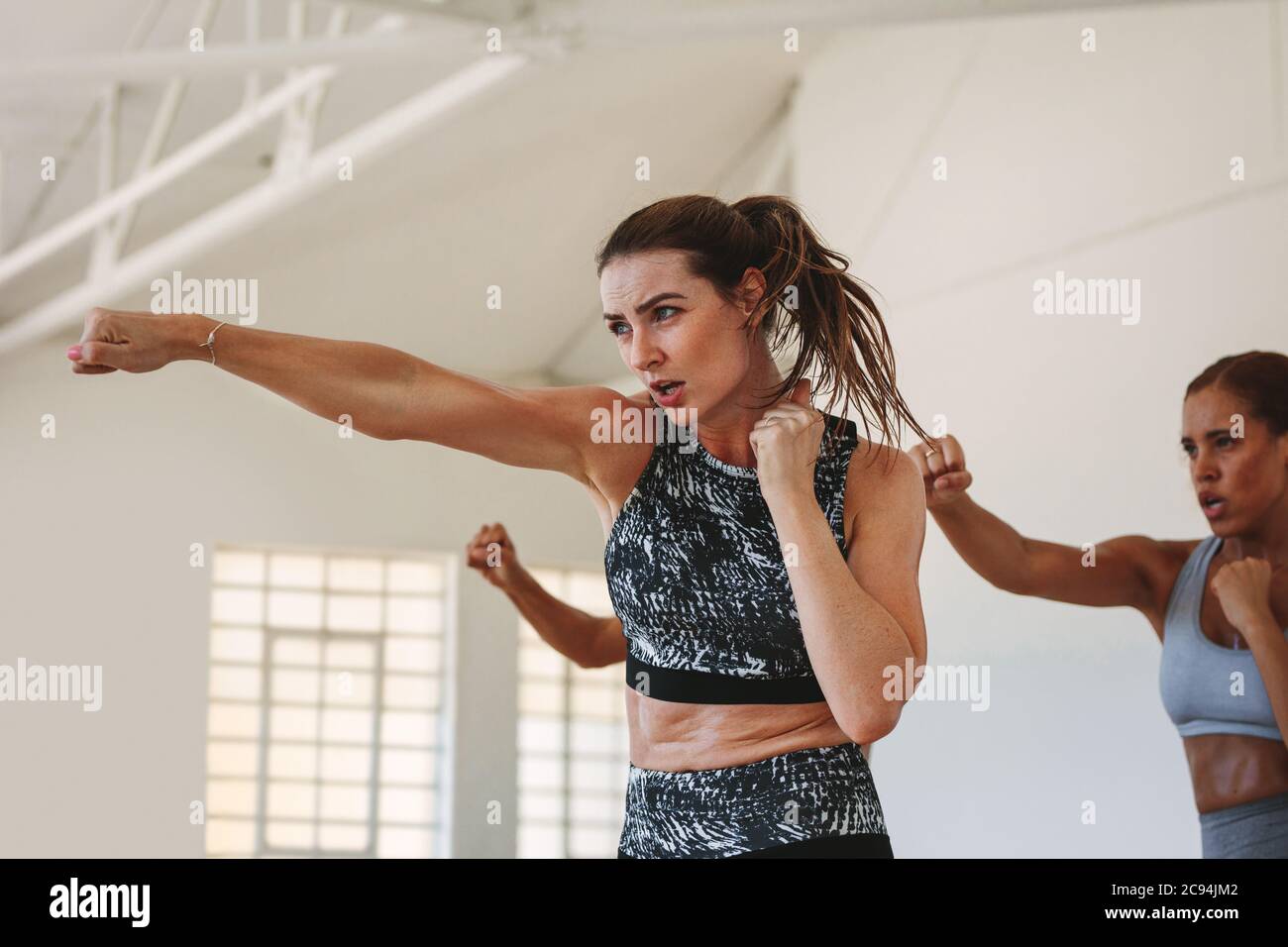 Close up of a fit woman doing punching exercises. fitness woman working on martial arts punches at a gym. Stock Photo