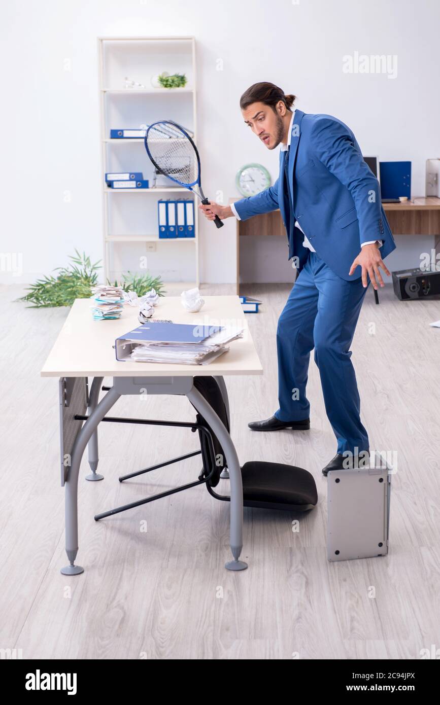 Young employee playing tennis in the office Stock Photo