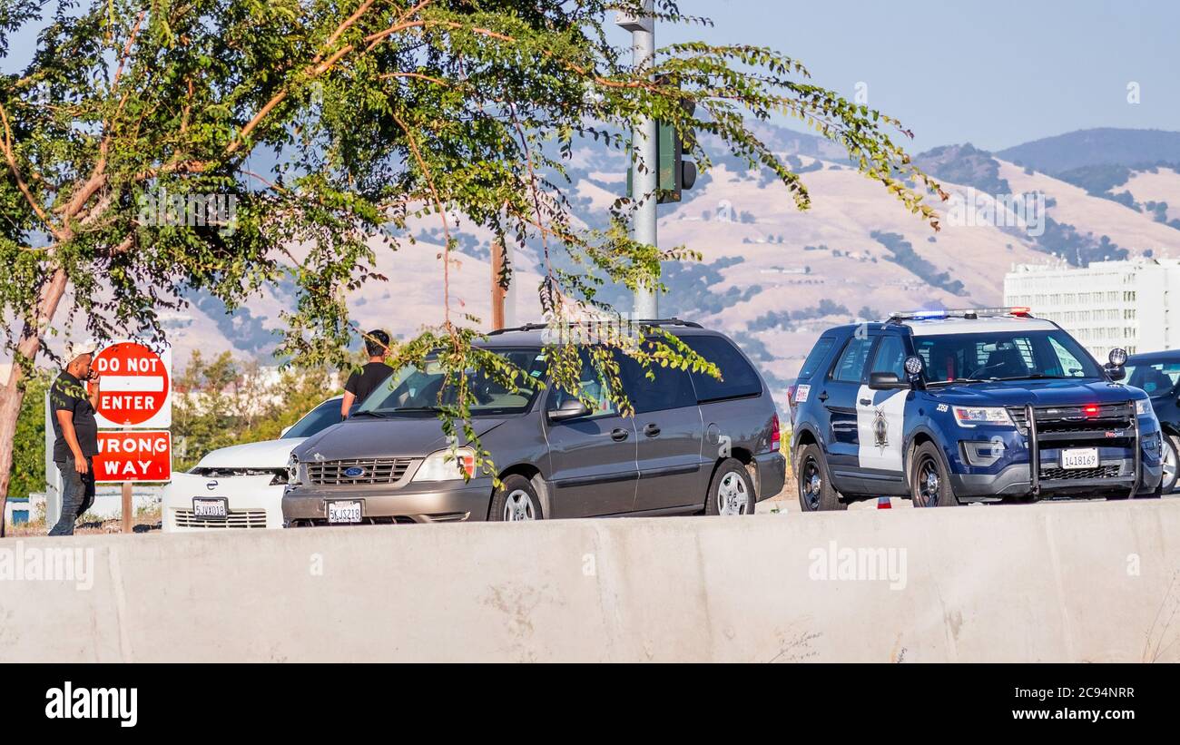 July 22, 2020 San Jose / CA / USA - Car crash site. Police car parked behind the two vehicles involved in the collision; Stock Photo