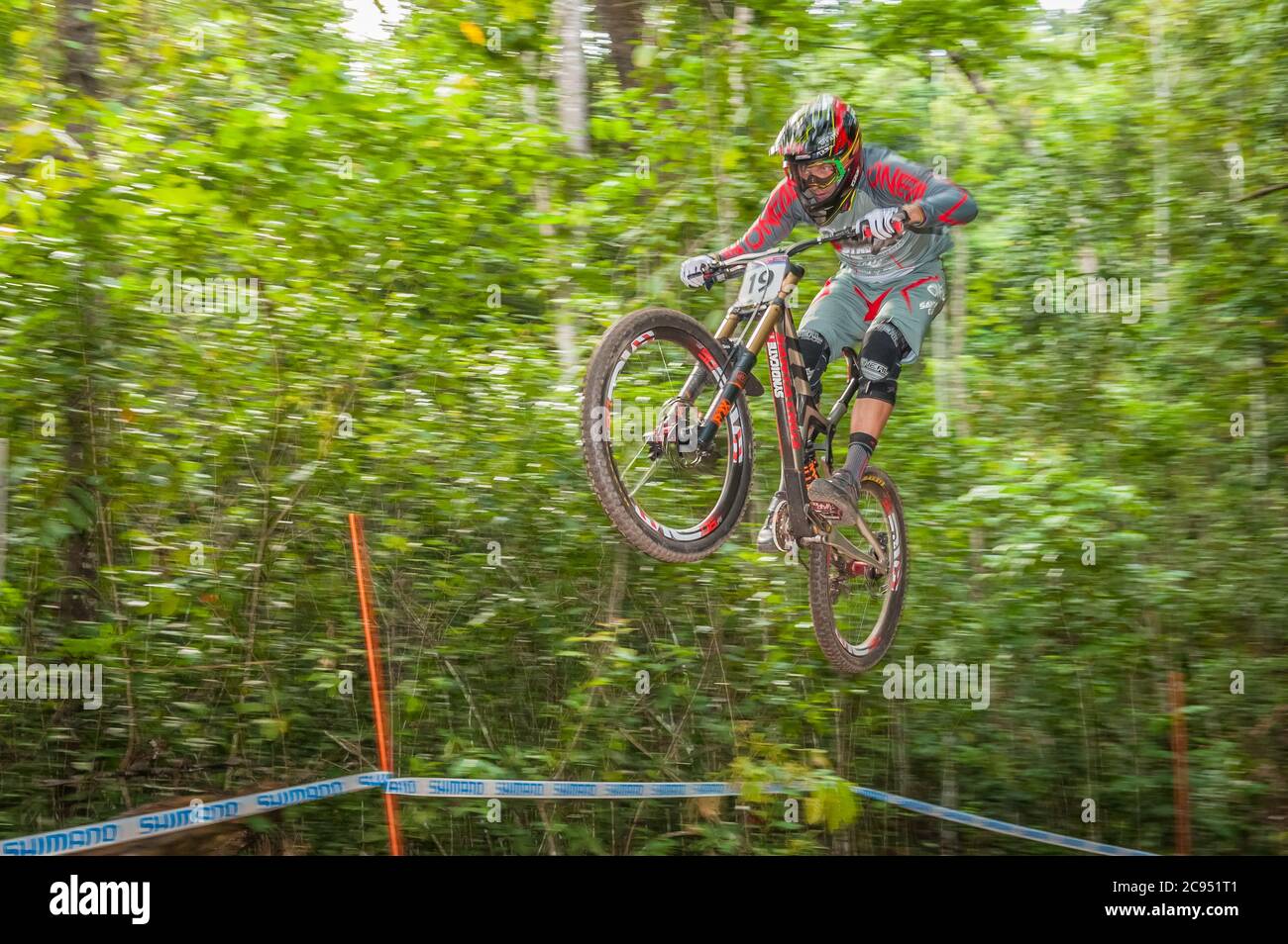 World class male competitor is airborne at the 2016 UCI World Downhill Mountain bike Championships held in Cairns, Australia. Stock Photo