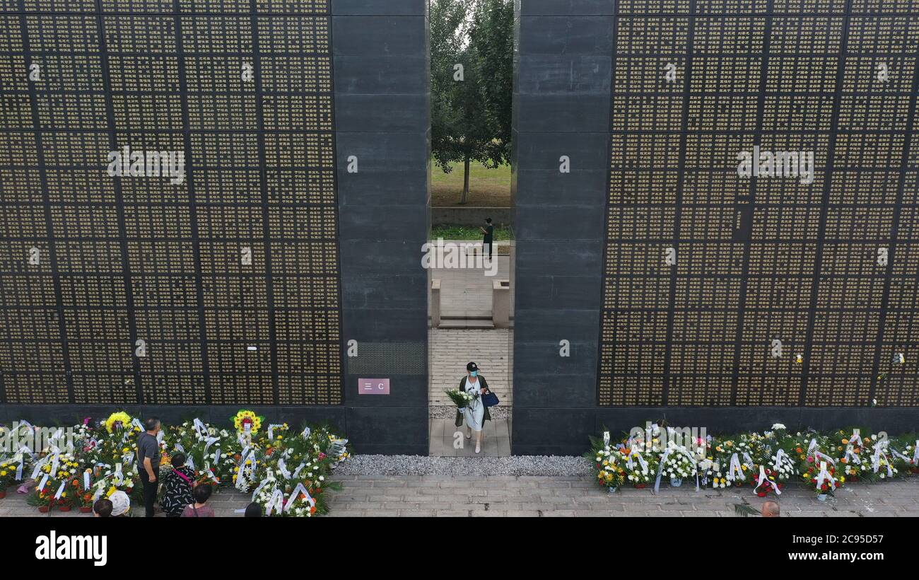 Beijing, China. 28th July, 2020. A woman holding flowers walks past memorial walls in Tangshan, north China's Hebei Province, in this aerial photo taken on July 28, 2020, the 44th anniversary of the 1976 Tangshan Earthquake. Credit: Dong Jun/Xinhua/Alamy Live News Stock Photo