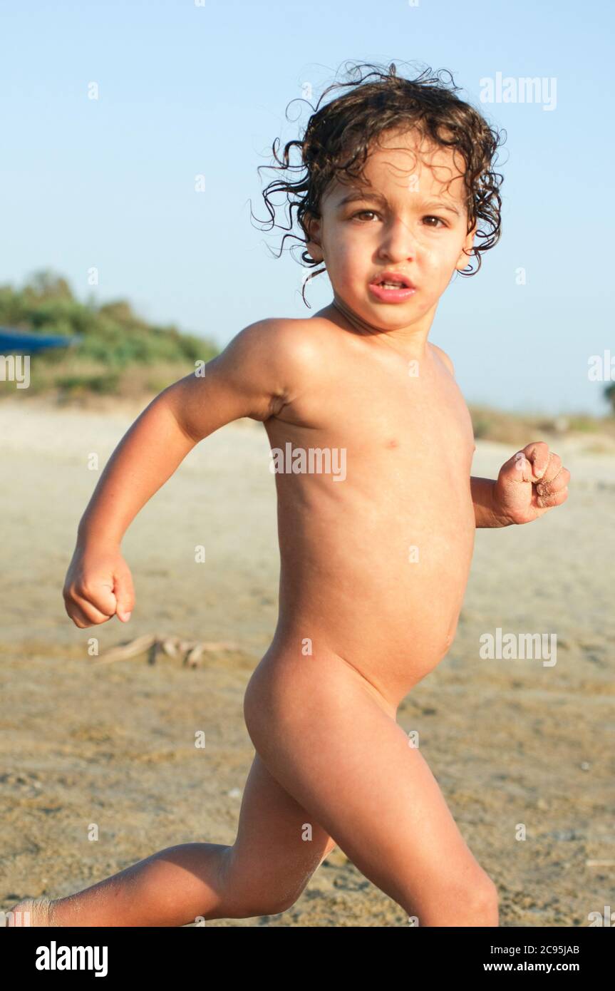 Toddler of three running on the beach Stock Photo