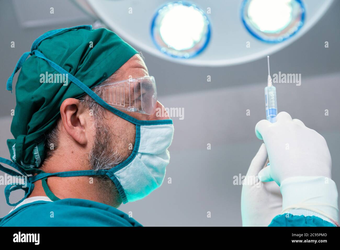 professional doctor holding general anesthetic medicine or antiviral drug vaccine needle syringe for patient before surgery in the operating room at t Stock Photo