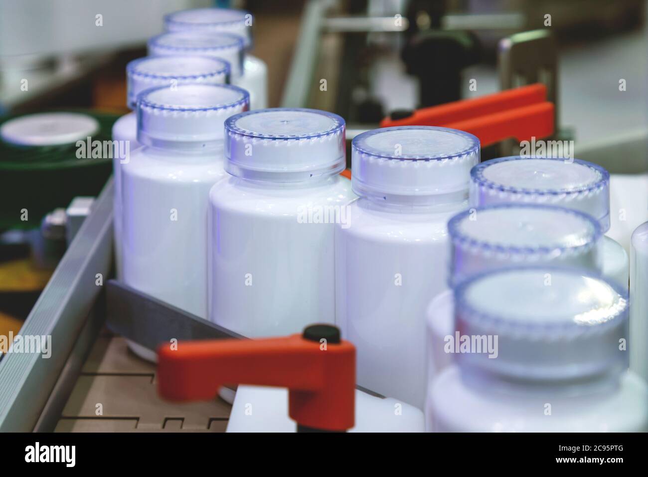 white plastic bottle on the production line of the conveyor at filling machine in the medical factory. selective focus. Stock Photo