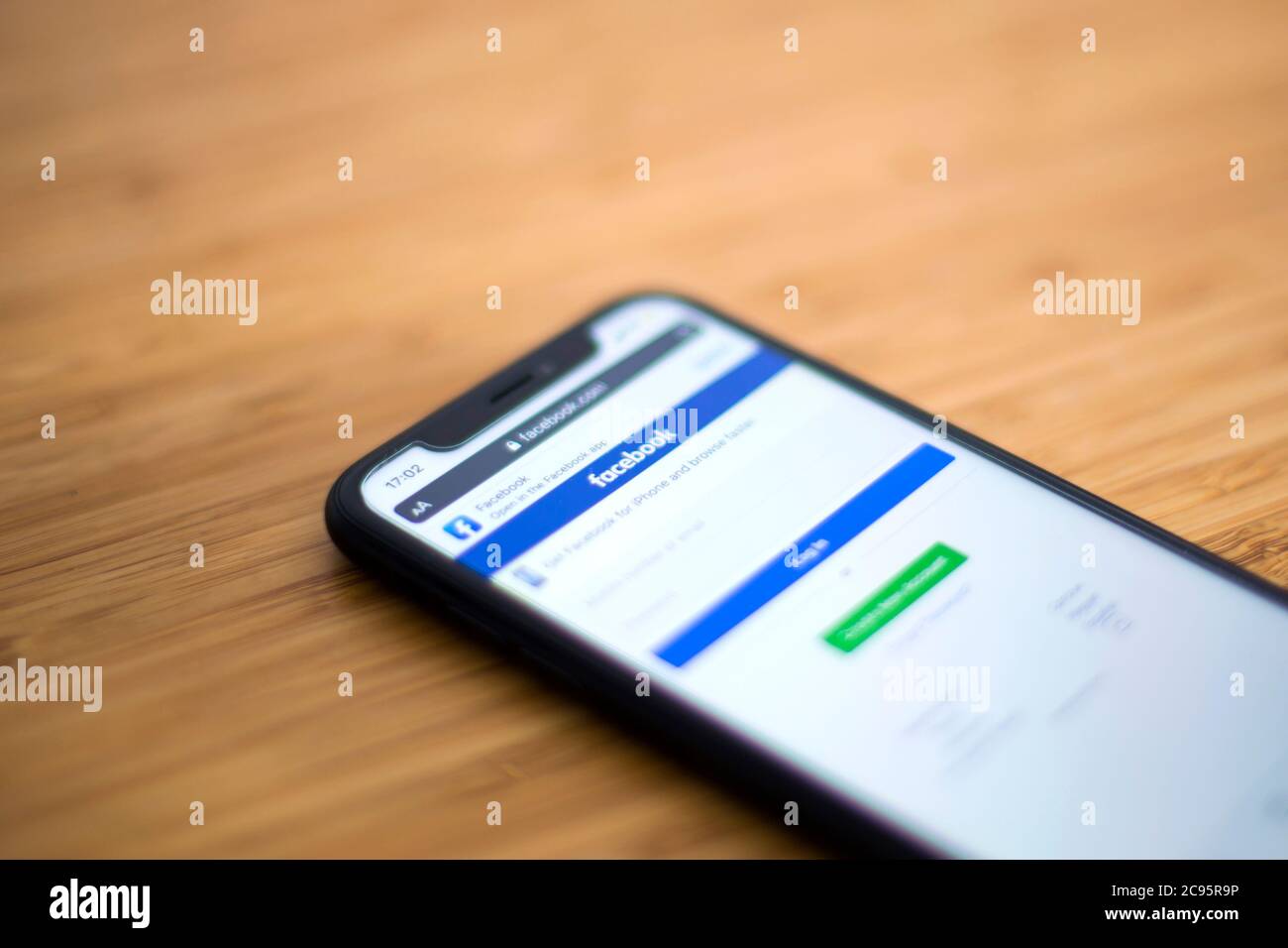 Facebook application on mobile phone. It is an American social media conglomerate corporation, founded at 2004. Stock Photo