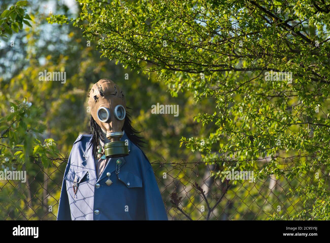 mannequin, scarecrow with gas mask in nature background symbolizing air pollution problem, global spread of the virus on the planet, chemical catastro Stock Photo