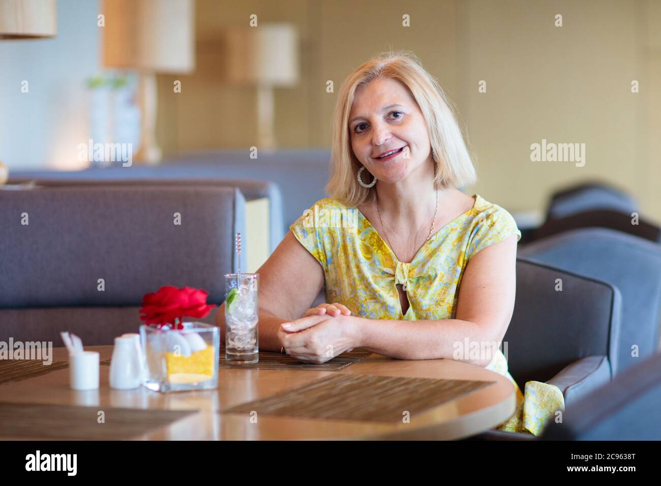 Senior woman having lunch in cafe. Lady in restaurant. Active retirement. Travel and vacation for retired female. Healthy juice drink for breakfast in Stock Photo