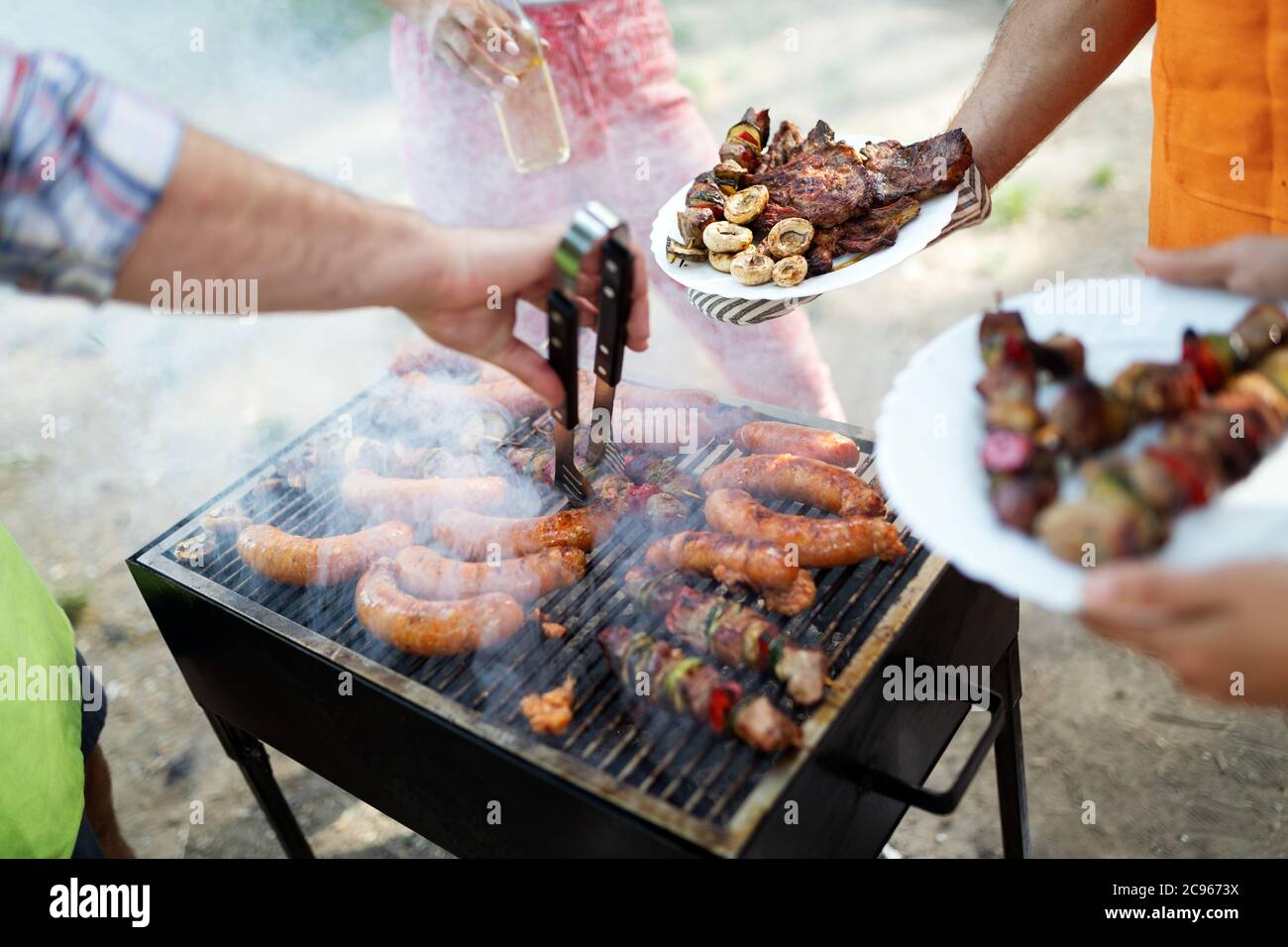 Selection of meat grilling over the coals on a portable barbecue Stock Photo