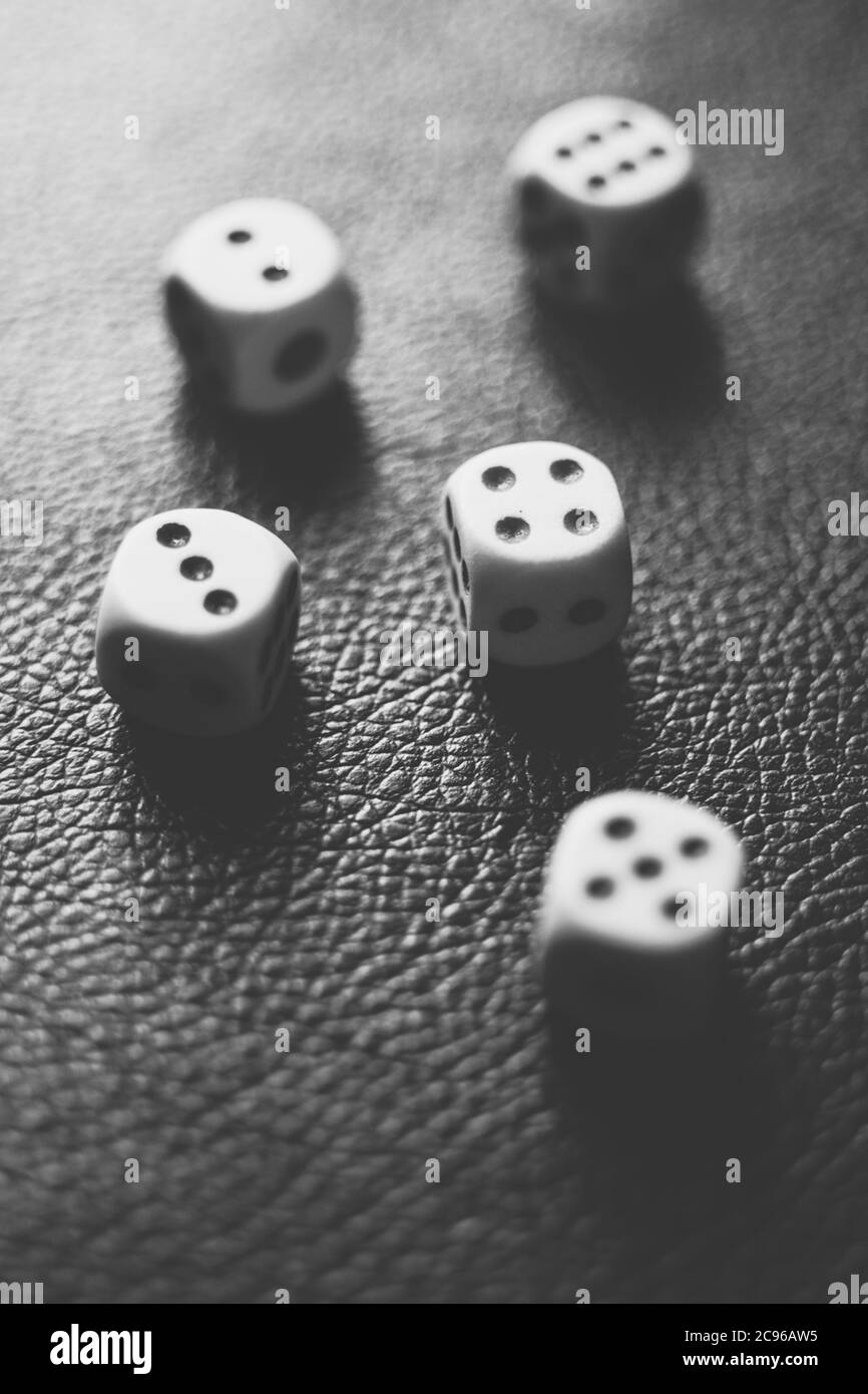 Dice squares on a black table. Black and white photo. Stock Photo